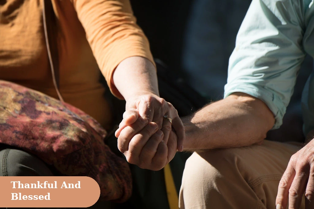 Thankful and blessed thanksgiving captions for instagram with a couple holding hands in warm sunlight